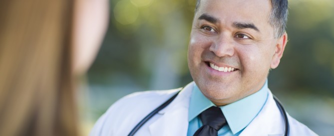Hispanic Male Doctor or Nurse Talking With a Patient Outdoors.